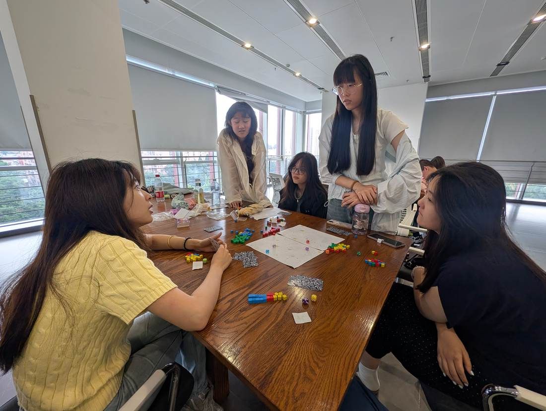 Students playing a game around a classroom table