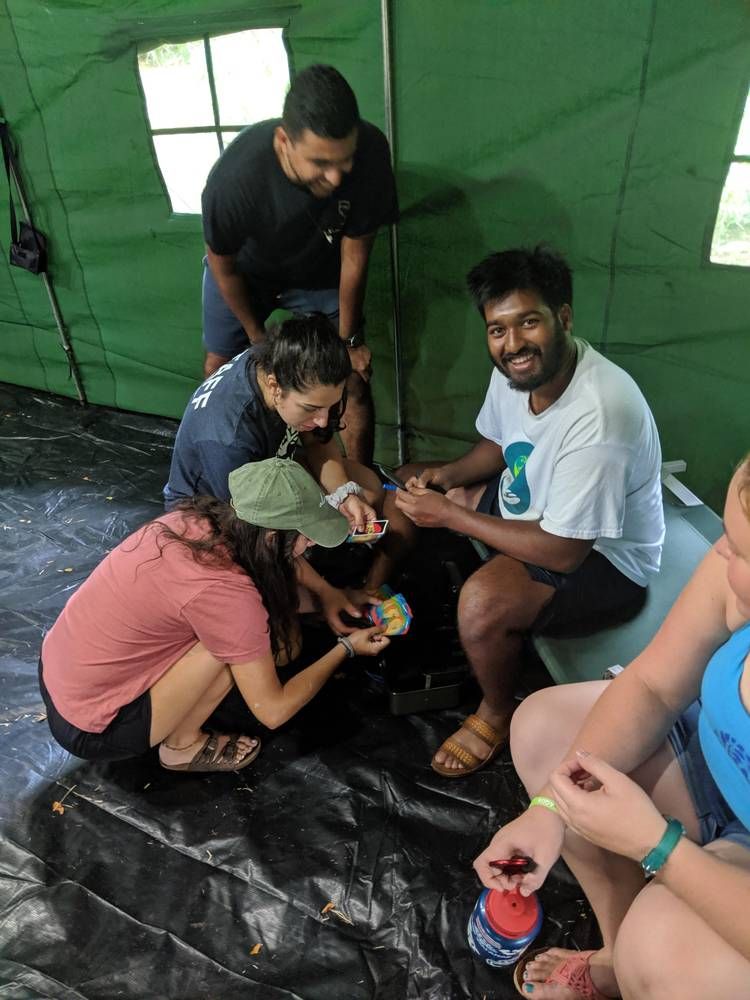 Adults solving an escape room puzzle in a tent